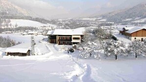 A snow-covered village with buildings, a clear sky, and a valley in the background. - Vacation apartment 36 sqm, no. 1, covered terrace, kitchen, 1 living/bedroom, WLAN (Ruhpolding)