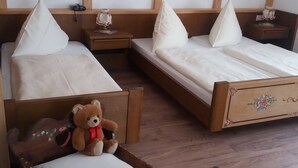 A hotel room with two single beds, wooden headboards, and a nightstand with a lamp. - Vacation apartment Ruhpolding 3 persons, 1 separate bedroom, terrace, 48 sqm (Inzell)