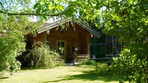 A wooden cabin with a porch, surrounded by greenery. - Vacation apartment no. 2, 30 sqm, 1 bedroom, terrace, 4 stars, 3 pers. (Anger)