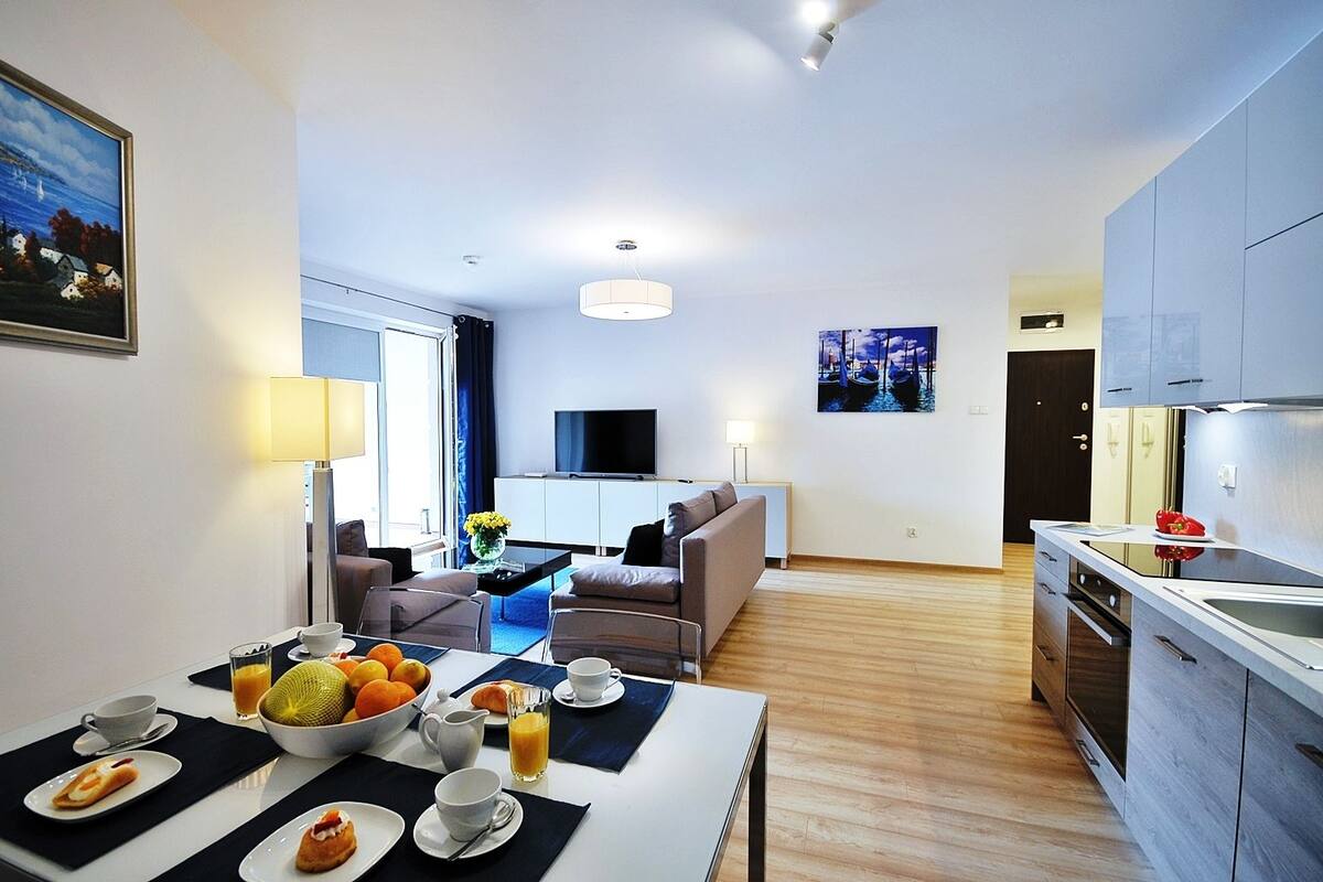 Ein modernes Hotelzimmer mit Essbereich, Wohnbereich und Küche.