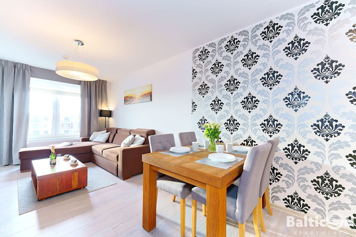 Ein modernes Wohnzimmer mit einem Holztisch, einem Esstisch und einem Sofa.