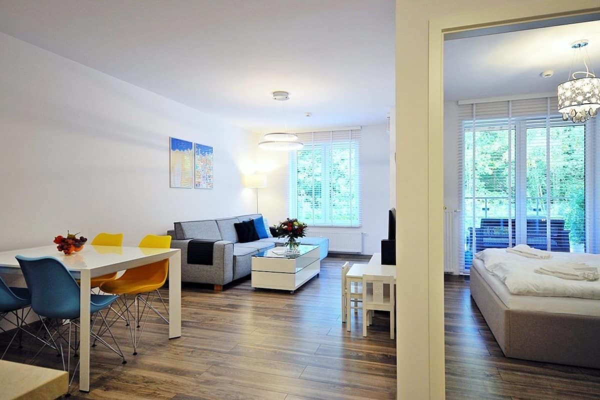 Ein modernes Wohnzimmer mit Essbereich, einer Couch und einem Bett.