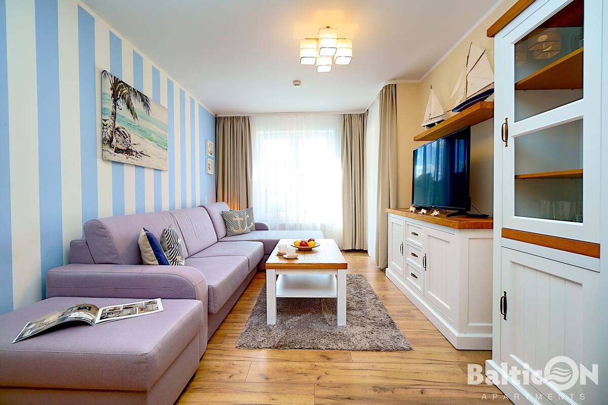 Ein modernes Wohnzimmer mit Sofa, Couchtisch und Fernseher.