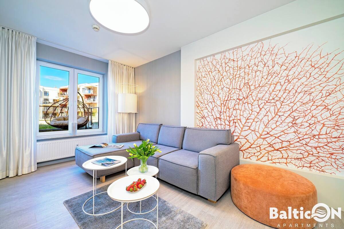 Ein modernes Wohnzimmer mit einem grauen Sofa, einem runden Couchtisch und einem großen abstrakten Wandbild.