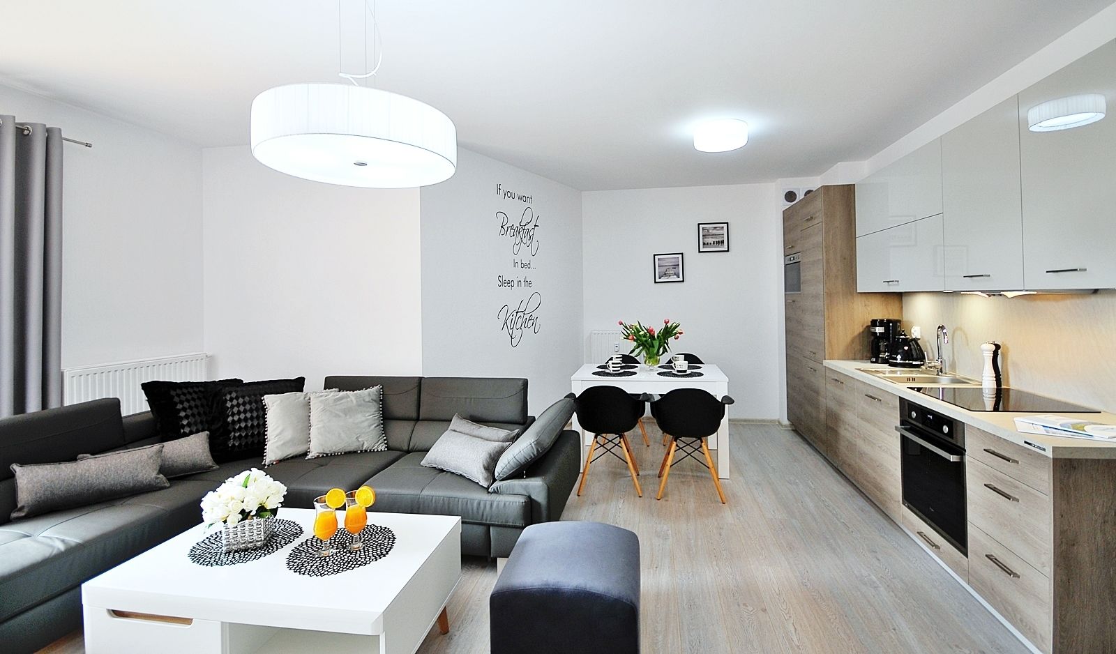 A modern living room with a sofa, coffee table, and dining area.