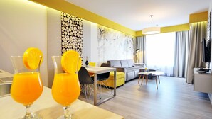 Une chambre d’hôtel moderne dotée d’un coin repas, d’un canapé et d’une télévision.