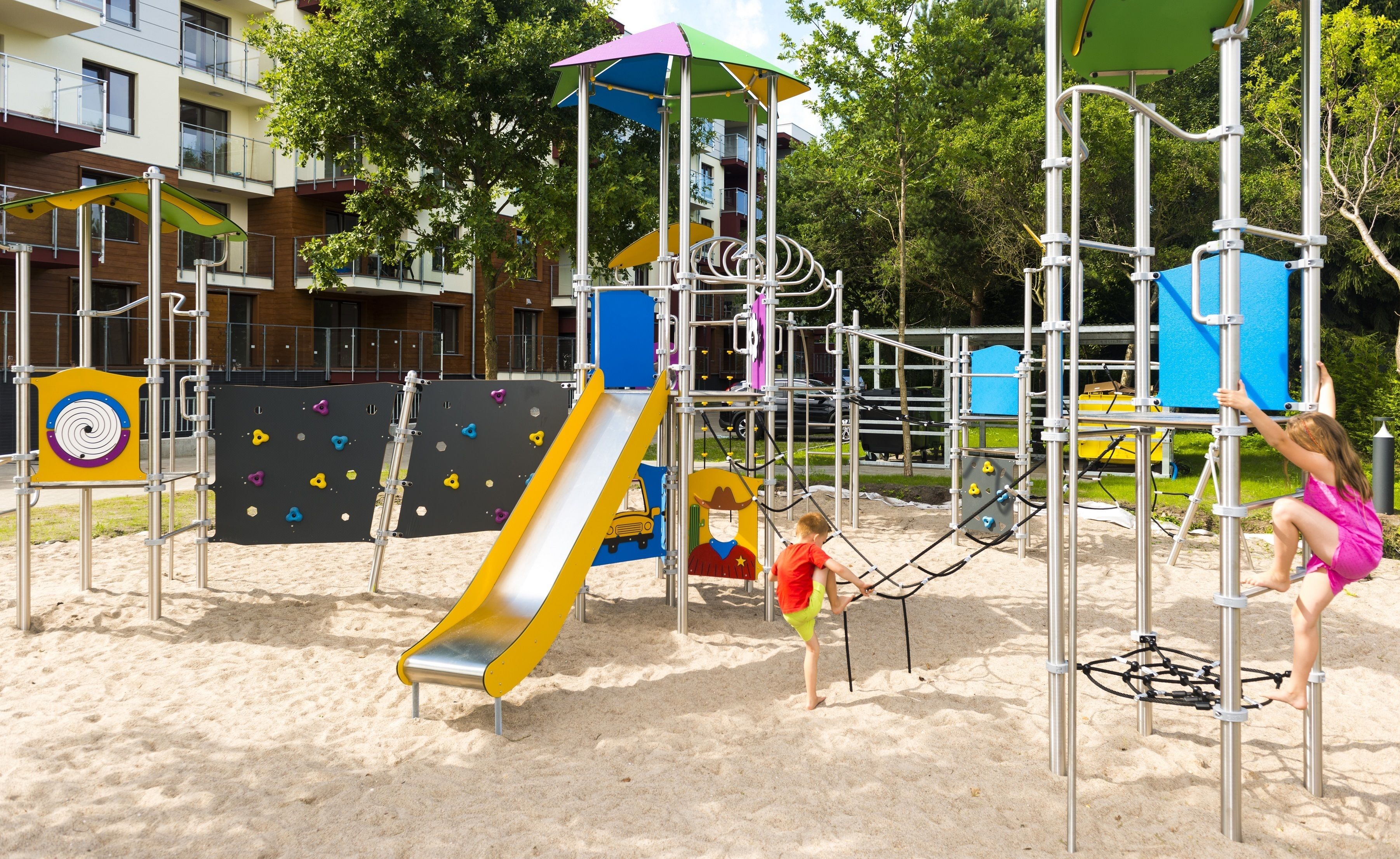 A playground with a slide, climbing structures, and a swing set.