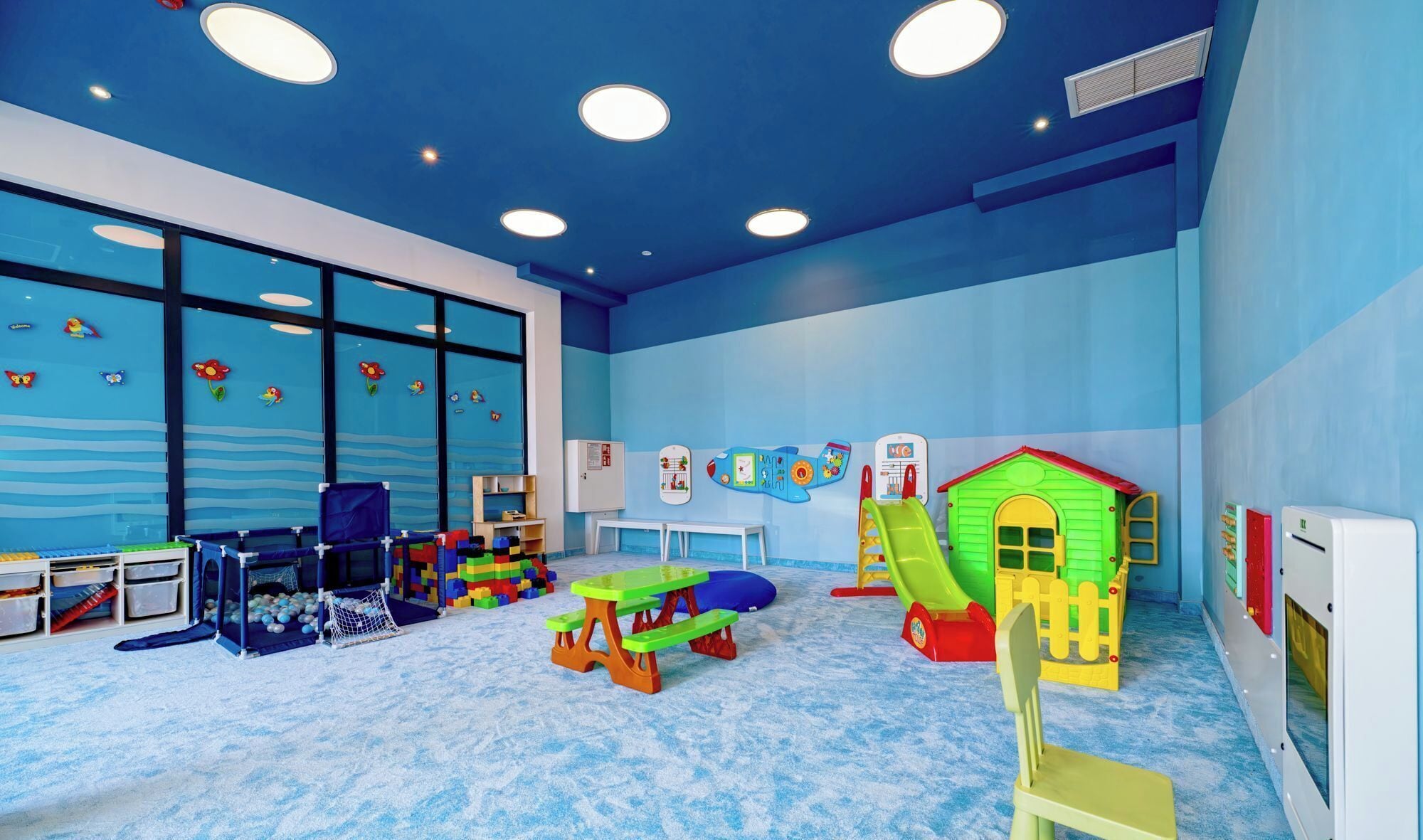 A children's play area with a slide, playhouse, and various toys.