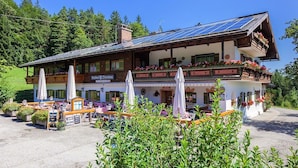 A traditional Alpine-style building with a dining area and outdoor seating. - Gasthof Dürrlehen (Berchtesgaden)