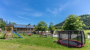 A playground with a slide, swings, and a trampoline. - Gasthof Dürrlehen (Berchtesgaden)