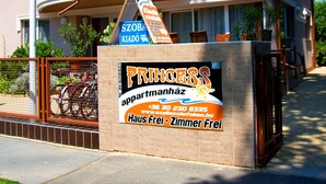 A two-story building with a balcony and a sign advertising "Princess" apartments. - Princess Apartman (Siófok)