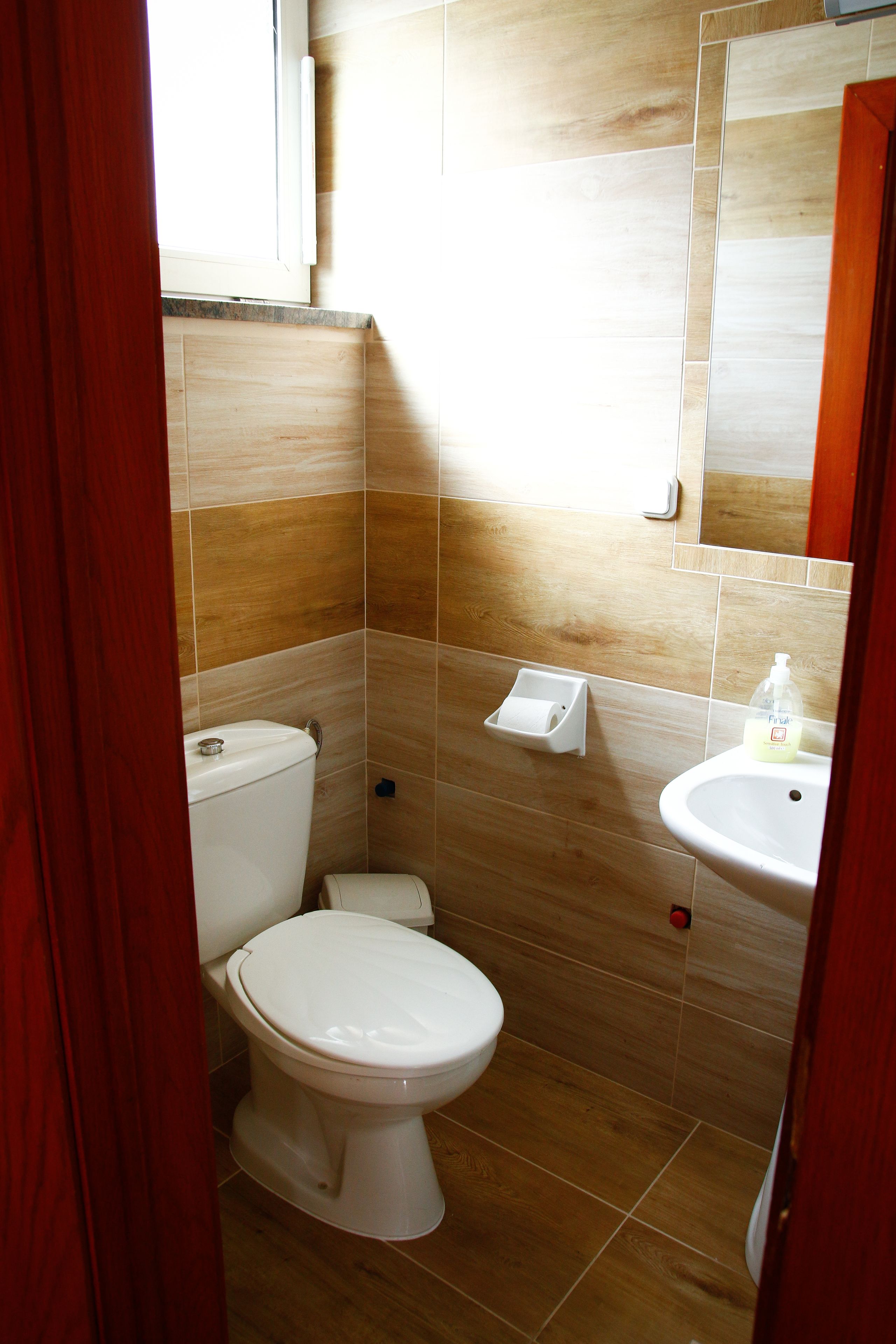 Une salle de bain avec des toilettes, un lavabo et un miroir.
