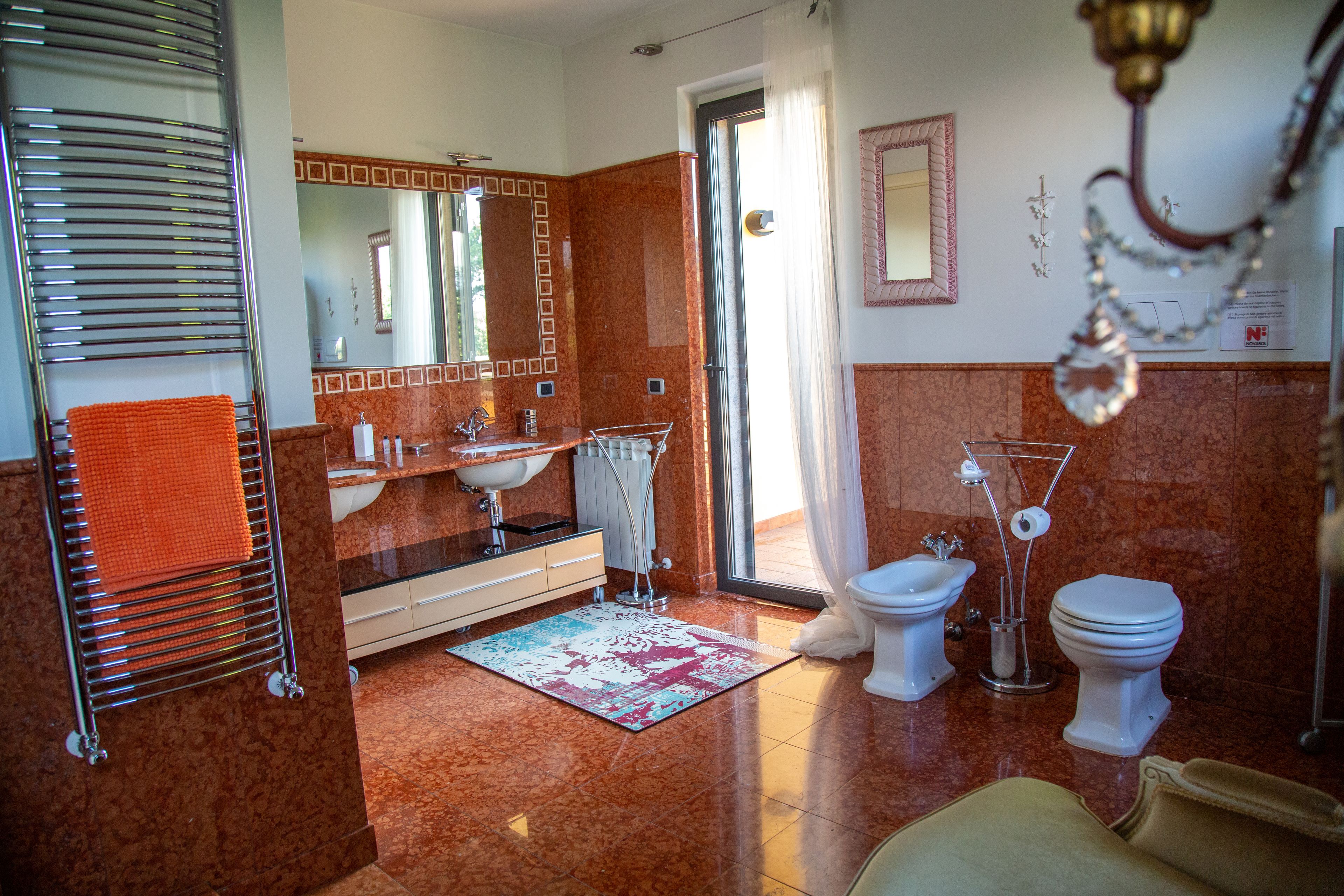 Un baño con suelo de mármol, un lavamanos, un bidé y un inodoro.
