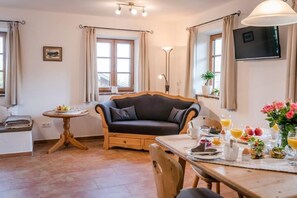 Relax in a warm and inviting space with a comfortable seating area, dining table, and flat-screen TV.