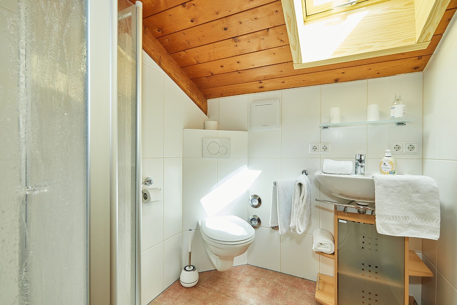 A bathroom with a toilet, sink, and shower.