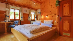 A wooden-paneled room with a bed, a desk, and a chair.