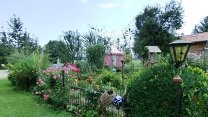 A garden with a variety of plants and flowers, a metal fence, and a lamp post. - House Efeu 90m², up to 6 persons, 3 separate bedrooms (Traunwalchen)