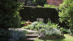 Un jardín cuidado con diversas plantas y un sendero de piedra.