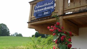 Un edificio in legno con un cartello che riporta la scritta "Schmuckhaus Ferienwohnung frei", che indica un appartamento per vacanze disponibile.