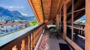 A wooden balcony with a view of houses and mountains. - Vacation apartment 3 for 2 persons, 50 sqm, 1 bedroom and balcony (Oberwössen)