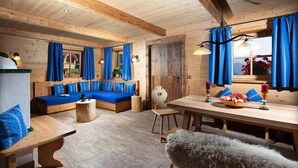 Acogedor interior de cabaña de madera con sofá, una mesa de comedor y una banca.