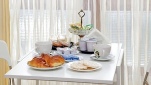 Ein Frühstückstisch mit Croissants, Gebäck und verschiedenen Getränken.