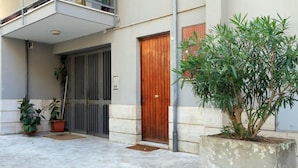 Ein Gebäude mit Holztür, einem Balkon und Blumentöpfen.