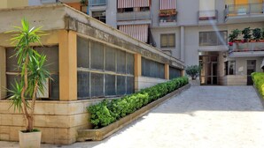 Ein Gebäude mit großen Fenstern, einem Betonweg und einem Blumentopf.