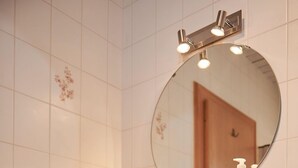 A bathroom with a white sink, a mirror, and a towel rack. - (202) Ein-Raum-Ferienwohnung (Reit im Winkl)