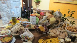 Una mesa con diferentes alimentos y botellas, probablemente para un bufé o reunión.