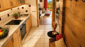 Una cocina con gabinetes de madera, salpicadero de azulejos y un comedor con mesa y sillas.