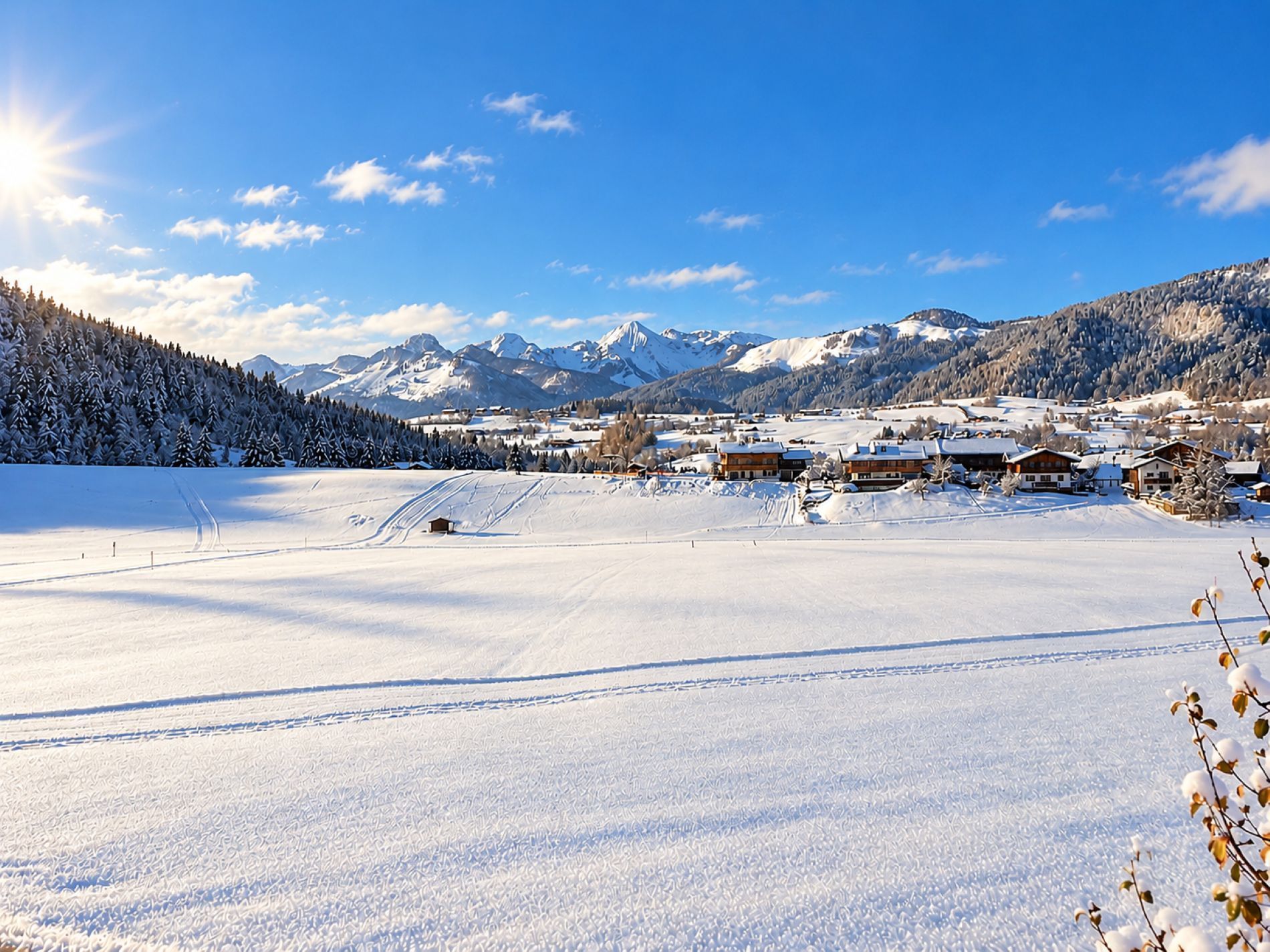 Paisatge cobert de neu amb cel serè, un altiplà al fons i alguns edificis al primer pla.