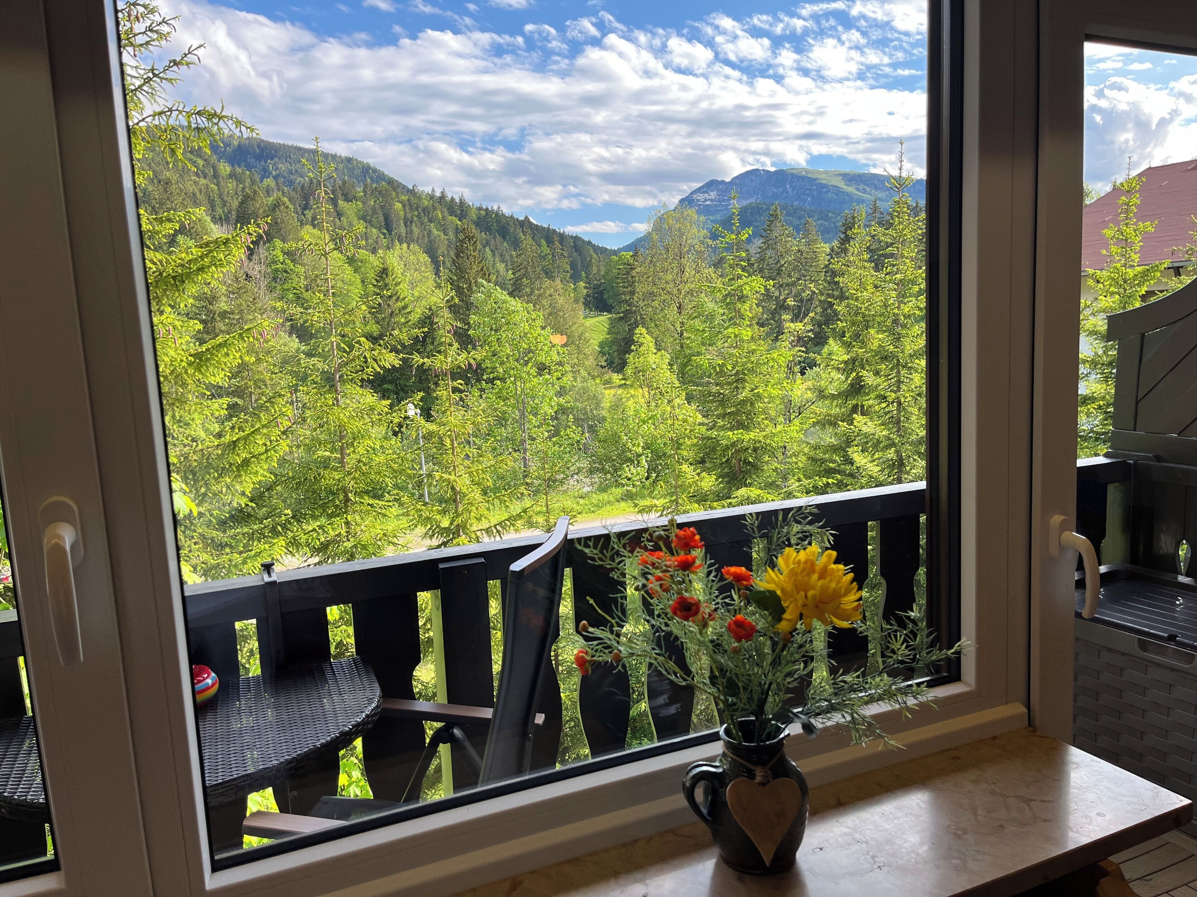 A balcony with a view of a forested mountain range.