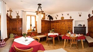 Une salle à manger traditionnelle avec des murs en bois, un lustre et une cheminée.