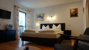 A hotel room with a bed, bedside table, lamp, and a TV mounted on the wall. - (08) Ein-Raum-Ferienwohnung 33qm, Dusche/WC, Koschnische, Balkon (Reit im Winkl)