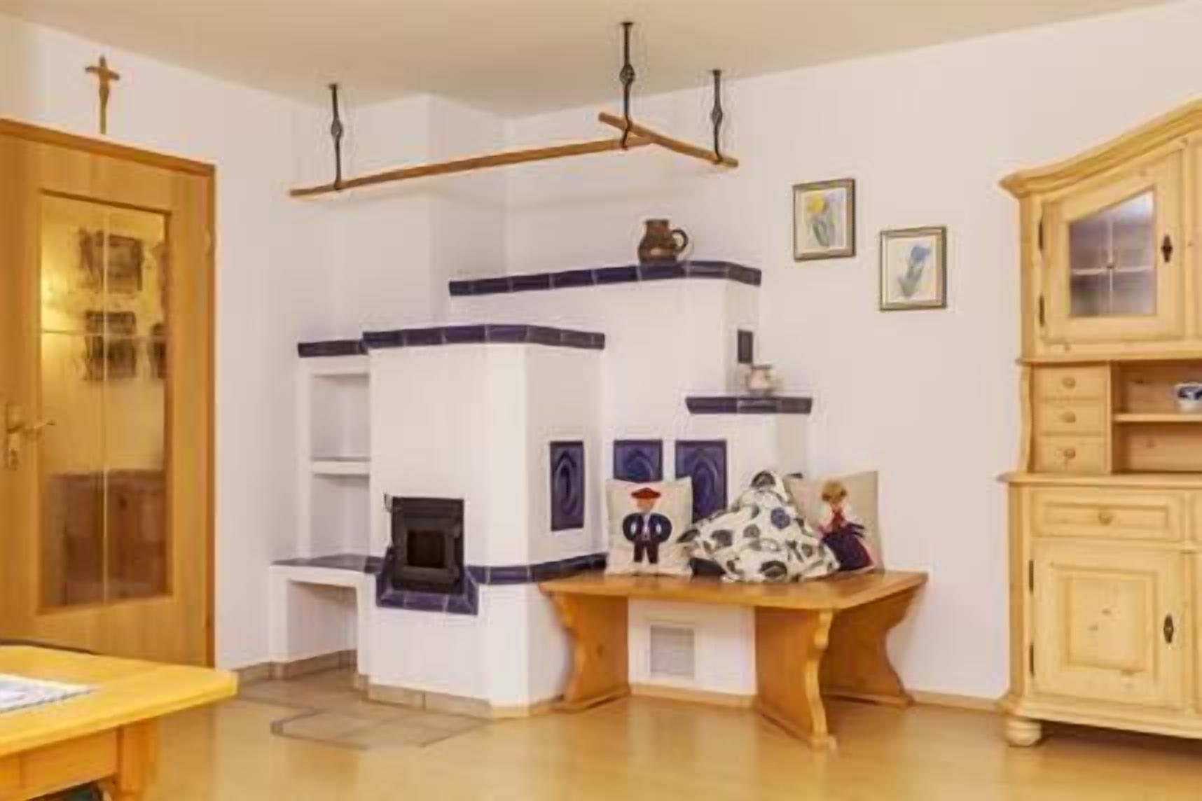 A room with a wooden cabinet, a small table, and a wall-mounted shelf with decorative items.
