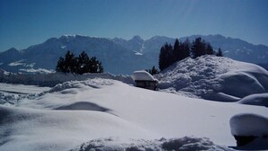 A snowy landscape with mountains in the background and a clear sky.