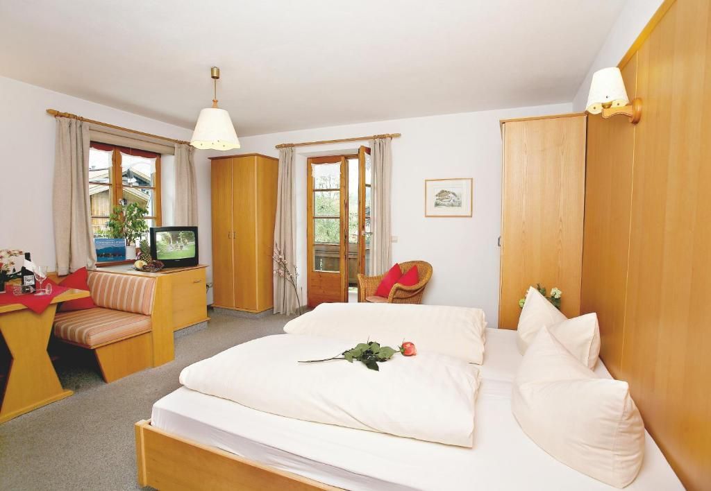 Ett hotellrum med en säng, en tv, ett skrivbord med en stol och ett fönster.