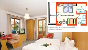 A hotel room with a bed, a TV, a desk with a chair, and a balcony with a view. - Ein-Raum-Ferienwohnung (2) 28qm, Dusche/WC, Küchenzeile, Balkon (Reit im Winkl)