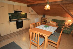 Enjoy a warm meal in this inviting kitchen and dining area, complete with a modern stove and comfortable seating.