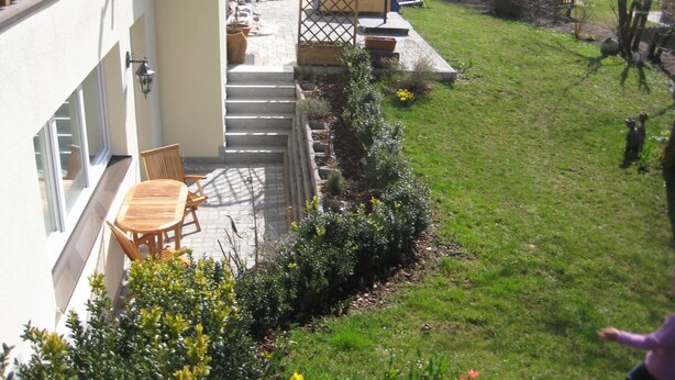 A patio with outdoor furniture, a small garden, and a view of the surrounding area. - Ferienwohnung für 1-2 Personen (Marktschellenberg)