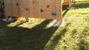 Eine hölzerne Kletterkonstruktion mit bunten Haltegriffen.