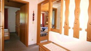 Ein Zimmer mit Holzmöbeln, einem Spiegel und einem kleinen Tisch.