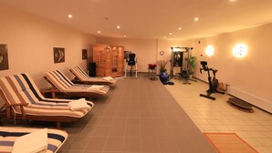 A spa room with multiple sun loungers, a massage chair, and exercise equipment. - Ferienwohnung Fellhorn (Reit im Winkl)