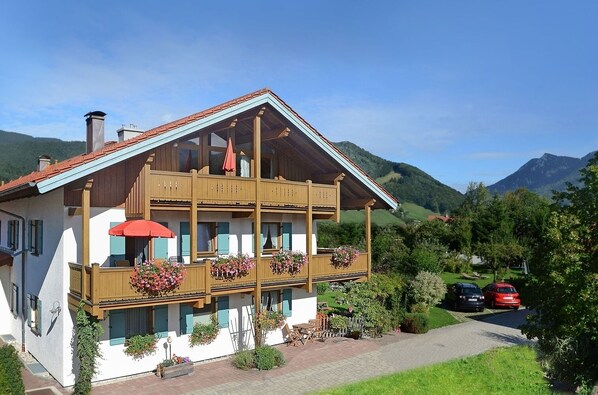 A two-story chalet with balconies, wooden railings, and flower boxes.