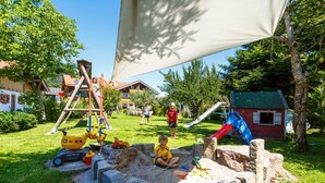 Ein Spielplatz mit Rutsche, Klettergerüsten und Sandkasten.