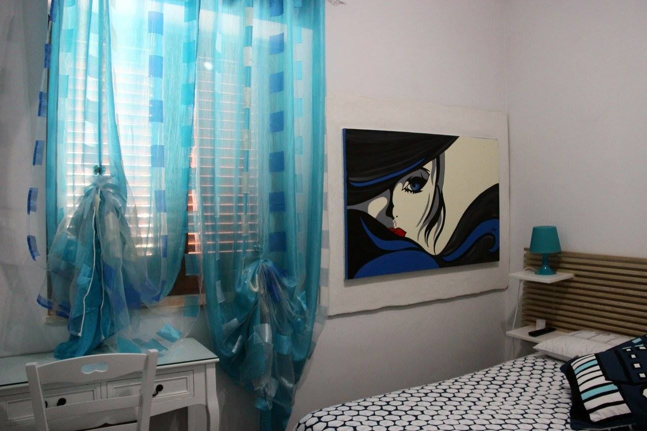 Un dormitorio con una cama, un escritorio y un cuadro en la pared.