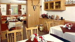 A rustic room with wooden furniture, a deer head mounted on the wall, and a cabinet with trophies. - (8) Zwei-Raum-Ferienwohnung 41qm, Dusche/WC, Extra-Schlafraum, Küche, 2 Balkone (Reit im Winkl)
