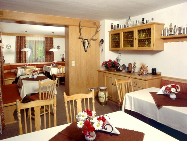 A rustic room with wooden furniture, a deer head mounted on the wall, and a cabinet with trophies. - (8) Zwei-Raum-Ferienwohnung 41qm, Dusche/WC, Extra-Schlafraum, Küche, 2 Balkone (Reit im Winkl)