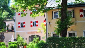 En byggnad med en skylt där det står ”SCHLOSSSEINKEMMER”.